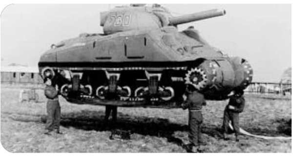 Four soldiers moving an inflatable tank