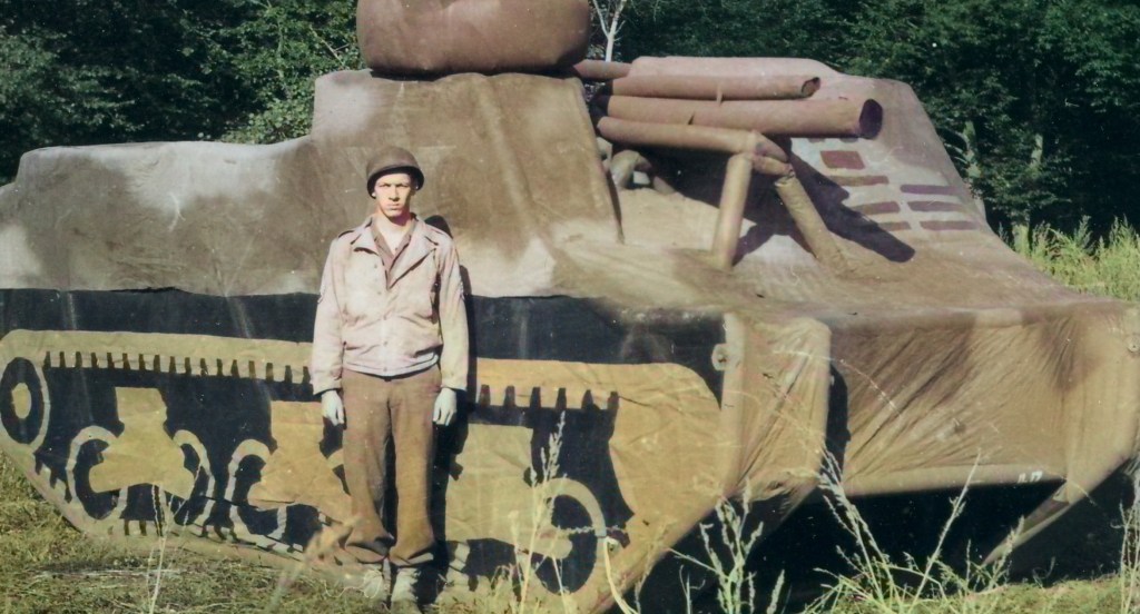 Soldier standing in front of an inflatable tank during WWII